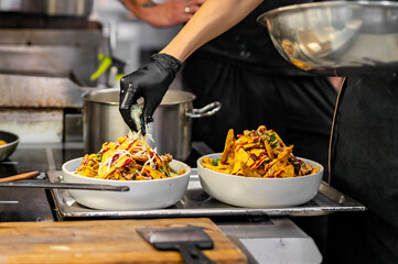 chef Cooking of crispy corn chips nachos at the restaurant kitchen