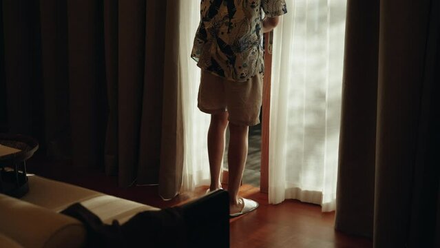Teen man from camera walk out hotel villa room using sliding door on vacation holiday
