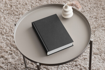 Black book mockup with a pampas decoration on the beige table.