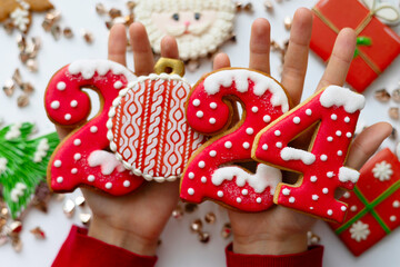 Banner for Christmas and New Year gingerbread cookies numbers 2024 on white background in child hands