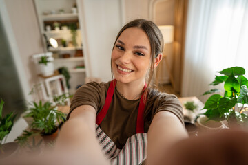 One woman young caucasian female stand at home hold flower plants pot