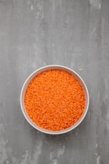 uncooked Red lentils in white bowl on ceramic