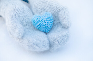Female hands in mittens with heart, close-up