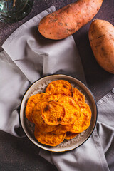 Homemade sliced baked sweet potato on a plate on the table top and vertical view