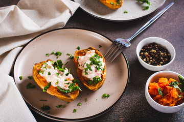 Baked sweet potato filled with ricotta, tomato and parsley on a plate