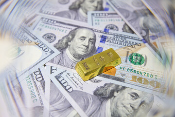 gold bar isolated on US 100 dollar banknotes