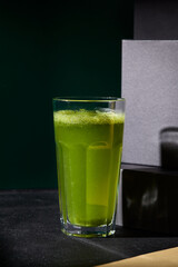 Refreshing green lemonade with basil served in a highball glass, highlighted against a dramatic black background, embodying a healthy lifestyle choice