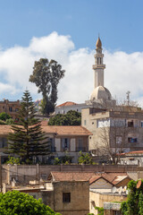 Fototapeta na wymiar View of the El Nasr Mosque, Scala, Algiers, Alger, Algeria. Residentials building, green trees, blue sky and white clouds.