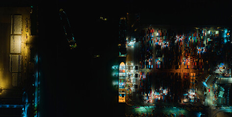 Aerial top view of container ship loading and unloading at cargo shipping port at night, Global...