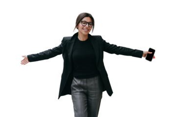 Successful businesswoman in black jacket against transparent background smiles eyes closed spreading hands feels free, accomplished all tasks. Happy student passed exams. Holds phones. Achievements