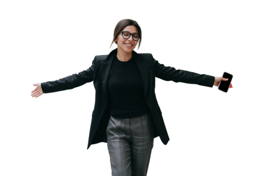 Successful businesswoman in black jacket against transparent background smiles eyes closed spreading hands feels free, accomplished all tasks. Happy student passed exams. Holds phones. Achievements - Powered by Adobe