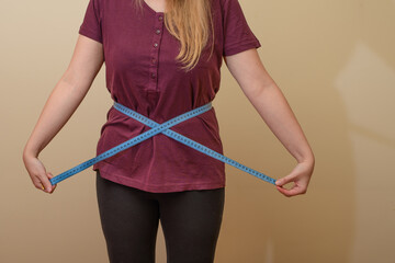 Kobieta mierzy swój obwód w talii