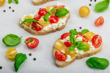Fresh bread sandwiches with tomato cherry, cream cheese and basil leaves. Morning breakfast concept