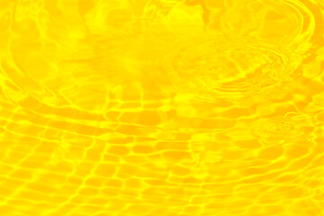 Defocus blurred transparent golden colored clear calm water surface texture with splashes...