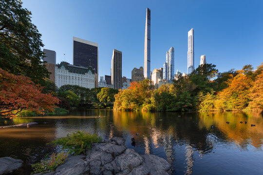 Central Park by The Pond in Fall with Billionaires Row supertall skyscrapers. Midtown Manhattan, New York City