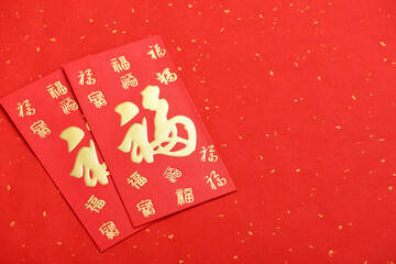 There are red envelopes on the red background of the Chinese New Year. The Chinese meaning in the picture is: good luck