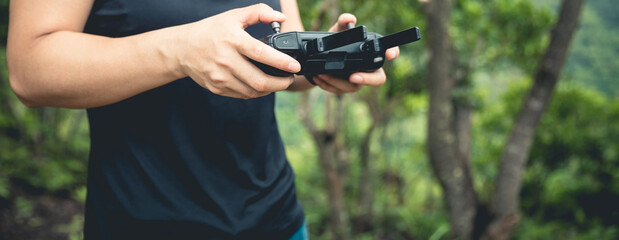 People remote control a flying drone in summer forest