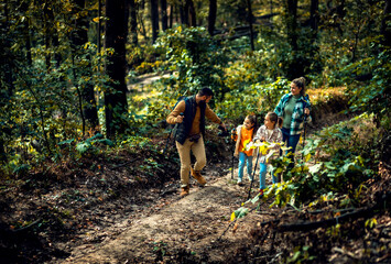 Naklejka premium Smiling family of four enjoying hiking in trough forest.