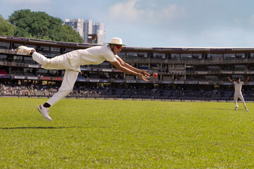A fielder about to catch the  ball during a cricket match