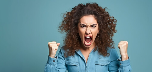 Young angry hispanic woman shouting in rage with clenched fists