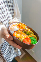 手作りのお弁当を持つ女性