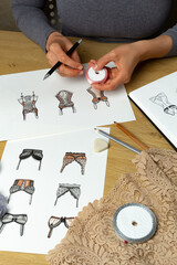 The designer draws sketches of women's underwear. Lingerie panties and bra on paper.