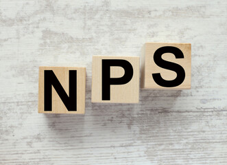 'NPS' - 'net promoter score' . Business concept, copy space. text on wooden cubes wooden background. foreground
