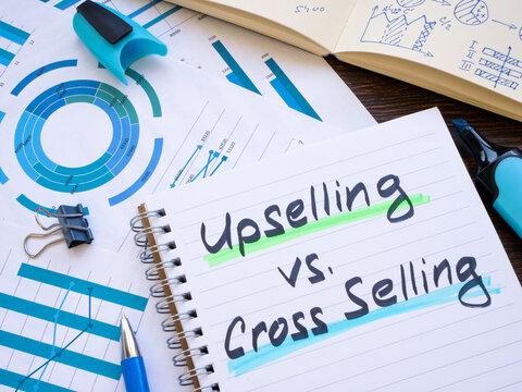 Notepad with inscriptions Upselling vs Cross-selling.