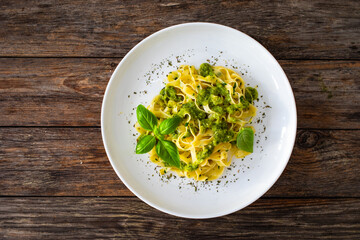 Tagliatelle with basil pesto sauce on wooden table
