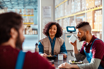Group of young and diverse workers having a lunch break in a warehouse