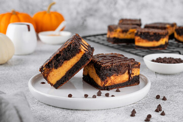 Chocolate brownies with spicy pumpkin cheesecake. Halloween or Thanksgiving dessert. Copy space.