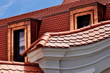 beavertail clay tile sloped residential roofs. bright shiny new copper plated roof dormers. new...