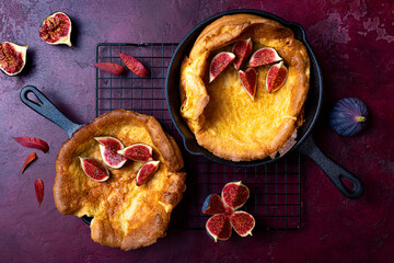 Dutch baby pancake with fresh figs and honey. Fall, autumn breakfast recipe. Pancake in a pan baked in the oven