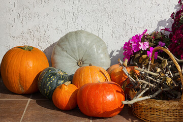 The porch of the house is decorated for Halloween with flowers and pumpkins.