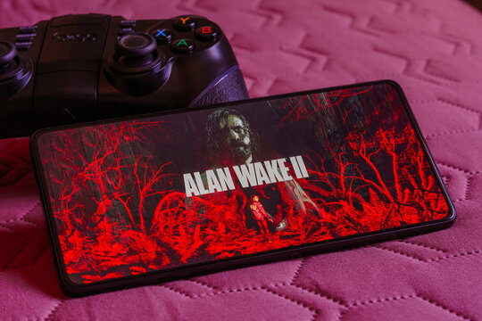 October 9, 2023, Brazil. In this photo illustration, the Alan Wake 2 logo is displayed on a smartphone screen, next to a gamepad.