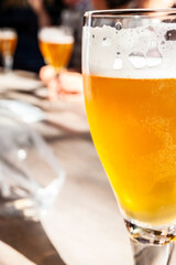 Close Up on a Glass of Beer and People Drinking in a Bar or Pub - 659477960