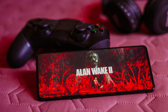 October 9, 2023, Brazil. In this photo illustration, the Alan Wake 2 logo is displayed on a smartphone screen, next to a gamepad.