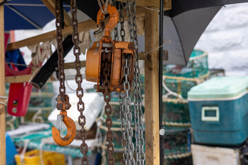 A seashore port town piled with fishery-related tools, chains, pulleys, and fishing nets