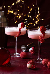 Lychee cocktail with white foam. Christmas lights on the background