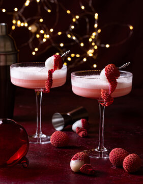 Lychee cocktail with white foam. Christmas lights on the background.