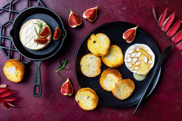 Baked Brie or Camembert cheese with toasted bread and fresh figs. Fall, autumn appetizer platter recipe
