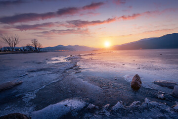 Frozen lake in South Korea in winter in sunrise and big trees in the background at Dumulmeori,...