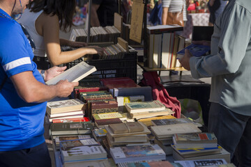 People looking for a book in a vintage market, blur background