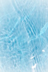 Defocus blurred transparent blue colored clear calm water surface texture with splashes reflection. Trendy abstract nature background. Water waves in sunlight with copy space. Blue watercolor shine.