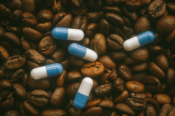 Pills in capsules on a background of coffee beans.
Close-up of medicine against coffee background.
Medicinal properties of caffeine.