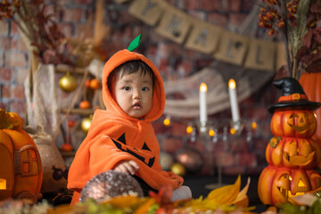 10月にハロウィンのフォトセットに囲まれて楽しそうな笑顔を見せる生後11か月の赤ちゃん