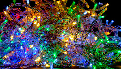 Colored New Year garlands with LED lamps are dropped in a chaotic manner. New Year decor, background