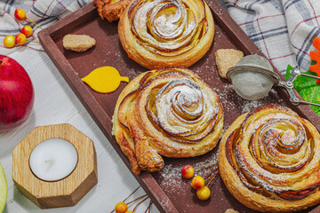 Apple roses pie with sugar powder. Traditional autumn baking, fall decor, flat lay