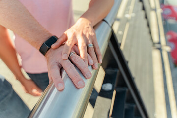 Obraz premium Beautiful wedding rings on hands of homosexual men closeup, selective focus. Relationship concept