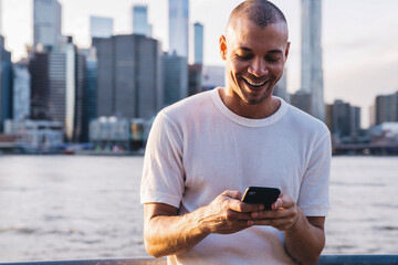 Laughing man in t-shirt leaning on fencing